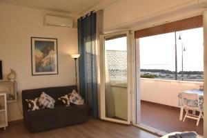 a living room with a couch and a sliding glass door at Mare e Relax 1 Melody Sea Front 10' da FCO Airport in Fiumicino