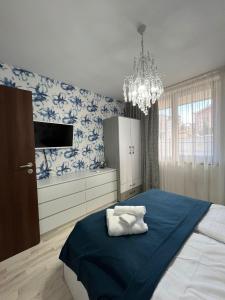 Un dormitorio con una cama con papel pintado azul y blanco. en Snowflake in Royal Park, Shuttle, SPA, en Bansko