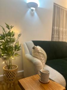 - un salon avec une tasse de café sur une table dans l'établissement Charming ground floor flat with parking - Maidenhead, à Maidenhead