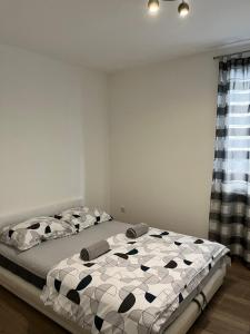 a bedroom with a bed with a black and white comforter at Apartman Teona in Novi Sad