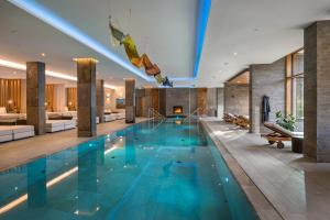 a large swimming pool in a hotel lobby at Klosterhof – Alpine Hideaway & Spa in Bad Reichenhall
