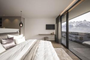 a bedroom with a large bed with a mountain view at Luxury Dolomites Apartments in Dobbiaco