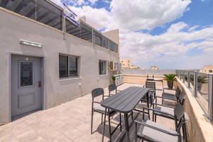 a patio with a table and chairs and the beach at וילה מינרל villa mineral in Neve Zohar