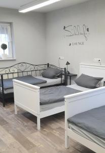 a bedroom with two beds and a sign on the wall at Gaestehaus-Alte-Druckerei-Wetzlar in Wetzlar