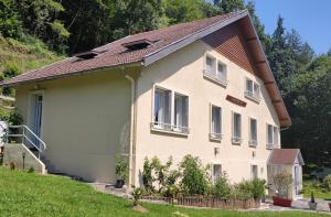 VoutezacAu fil de la Bontat Vézère的一栋白色房子，屋顶是棕色的。