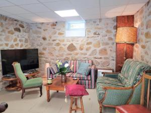 VoutezacAu fil de la Bontat Vézère的有两把椅子和一台电视的客厅