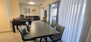 a dining room with a table and chairs and a piano at וילה מינרל villa mineral in Neve Zohar