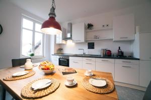 a kitchen with a wooden table with a bowl of fruit on it at DesignLodge Apartments in Bad Sobernheim +11 photos