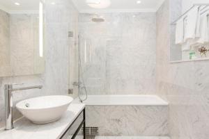 un bagno bianco con vasca, lavandino e vasca di Elite Hotel Adlon a Stoccolma