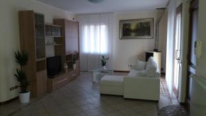 sala de estar con sofá blanco y TV en Silvy en Endine Gaiano