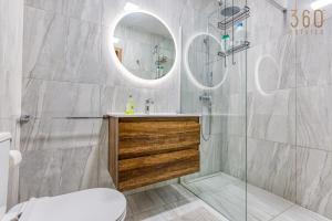 a bathroom with a sink and a shower with a mirror at Lovely 1BR Apt with full amenities in Bugibba by 360 Estates in St Paul's Bay