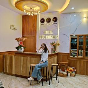 a woman sitting on a bar in a restaurant at KHÁCH SẠN ĐỨC CHÍNH 2 - Phan Rang in Bắc Sớn