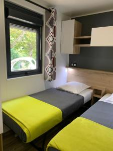Postel nebo postele na pokoji v ubytování Camping le mas des sedaries, clim + 9 fotografií