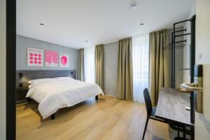 Un pat sau paturi într-o cameră la Hôtel Arnold self check-in