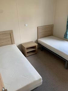 two beds in a room with two tables at Clearwater Lodge - 392 Valencia Heights in Greatstone +9 photos