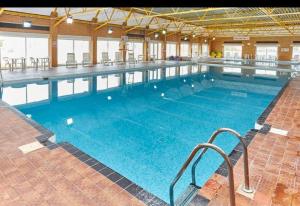 a large swimming pool with blue water in a building at Clearwater Lodge - 392 Valencia Heights in Greatstone