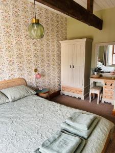 a bedroom with a bed and a dresser and a mirror at Copley Cottage in Copley