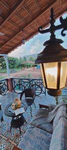 a lamp on a patio with a couch and a table at Paradise Farm Alibaug in Bhāweghar