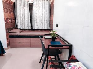 a small room with a table and chairs and a window at Paradise Farm Alibaug in Bhāweghar