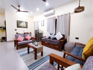 a living room with couches and a table at Paradise Farm Alibaug in Bhāweghar