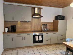 eine Küche mit weißen Schränken und einem Herd mit Backofen in der Unterkunft "Marianne" RE20 in Sögel