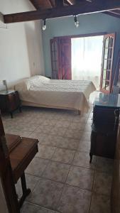 una camera da letto con un letto in una stanza con una finestra di Casita de Norma Faro a Mar del Plata