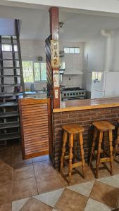 una cucina con bancone e due sgabelli in un bar di Casita de Norma Faro a Mar del Plata Altre 6 foto