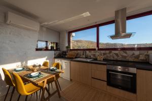 a kitchen with a table and yellow chairs in a kitchen at Petra Vista Retreats in Otziás