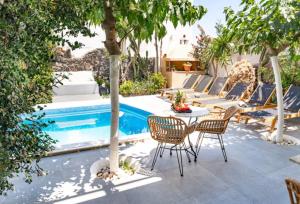 a patio with a table and chairs next to a pool at Danae Villa in Fira