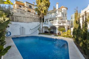 a large house with a swimming pool in front of it at Villa Nerja in Nerja