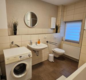 a bathroom with a washing machine and a sink at Bördeapartment am Heiderand 2 in Samswegen