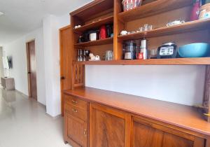 una cocina con un armario de madera y estanterías en Casa Qiru tu Refugio en Oxapampa, en Oxapampa 6 fotos más