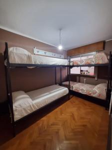two bunk beds in a room with a wooden floor at Rincon Salteño Hostel in Salta +22 photos