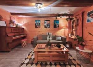 a living room with a couch and a piano at Chalet le Muveran in Gryon