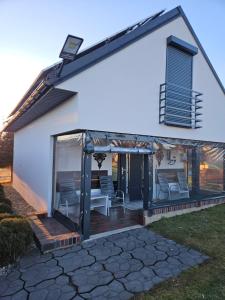 a house with a screened in porch with chairs at Domek rodzinny in Piekielnik