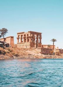 um edifício sobre uma colina ao lado de um corpo de água em 4 Days Nile Cruise from Luxor to Aswan em Luxor