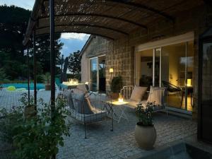 an outdoor patio with couches and a table and chairs at LOFT de BARTUEL à 5 min de NOGARO in Arblade-le-Haut