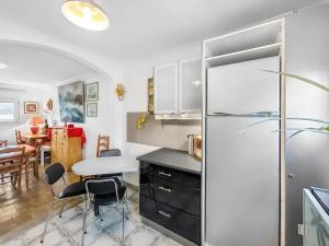 a kitchen with a refrigerator and a table with chairs at Maison charmante à Saint-Herblain avec jardin privé in Saint-Herblain