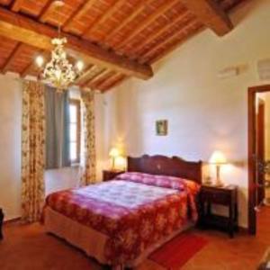 サン・ミニアートにあるTenuta Borgo al Soleのベッドとシャンデリアのある寝室