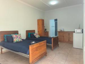 a living room with two beds and a kitchen at Sunny Stay in Groblersdal