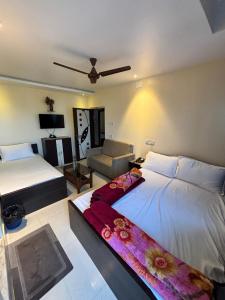 a bedroom with two beds and a living room at hotel sagnik in Murshidābād