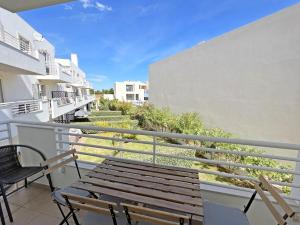 a balcony with a bench and chairs on a building at APF Beach T2 Cabanas Home by Junto ao Mar in Cabanas de Tavira