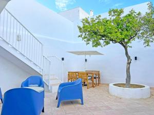a tree in a pot next to a table and chairs at Casa Florence - Fuseta in Fuzeta