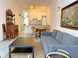 a living room with a blue couch and a table at Casa Florence - Fuseta in Fuzeta