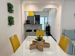 a kitchen and dining room with a table and yellow chairs at Casa Condessa de Cabanas by Junto ao Mar in Cabanas de Tavira