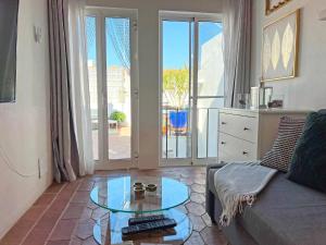 a living room with a couch and a glass table at Casa Salto Tavira by Junto ao Mar in Tavira