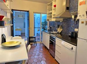a kitchen with white appliances and a table in it at Casa Salto Tavira by Junto ao Mar in Tavira