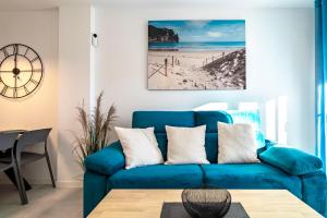 a blue couch in a living room with a beach at Apartment Laguna Azul in El Mojón +44 photos
