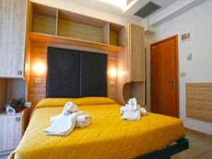two towels on a yellow bed in a room at Hotel Marebello in Rimini +19 photos