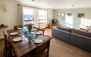 a living room with a table and a couch at 12 & 14 On the Hill Aberfoyle, twin holiday cottages in Scenic Loch Lomond & Trossachs National Park in Aberfoyle